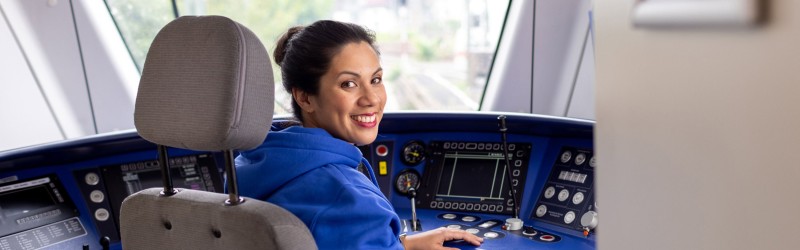 Eine lächelnde Zugführerin im Cockpit